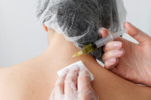 Mulher inserindo seringa na nuca