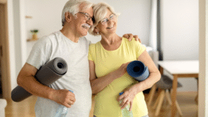 Casal idoso abraçado e segurando colchonetes, para falar sobre fraturas em idosos