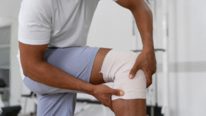 Homem com o joelho enfaixado, para falar sobre a ruptura dos ligamentos